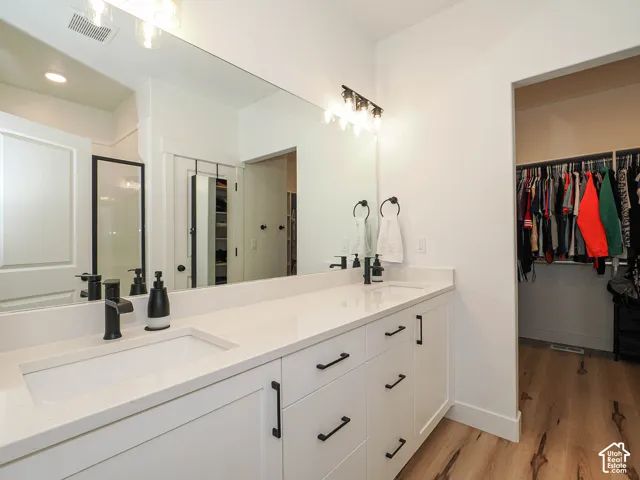 Dual vanity with white undermount sinks, stone countertops, and matte black fixtures