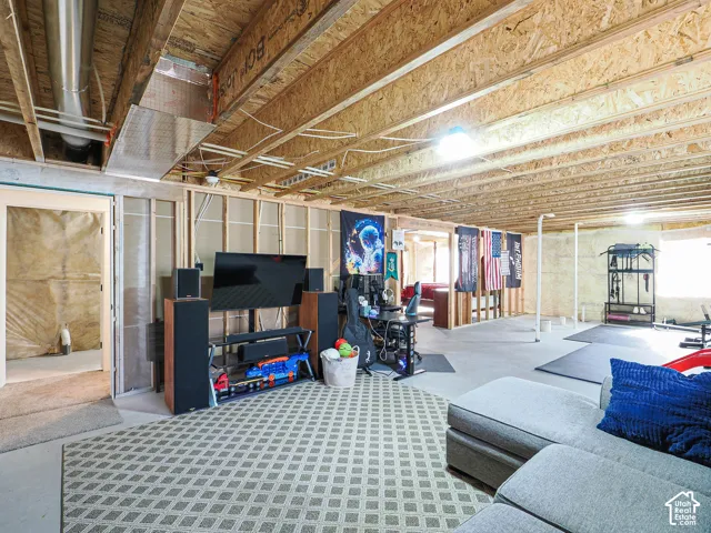 Unfinished basement with exposed ceiling joists and framing, concrete flooring, and recessed lighting