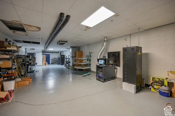 Industrial-style concrete flooring and drop ceiling with recessed lighting