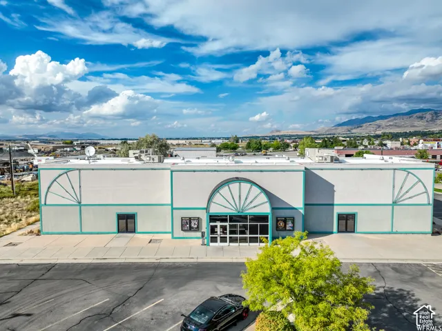 Commercial building featuring a prominent arched entryway, large glass doors, and a distinct exterior design with decorative arched panels