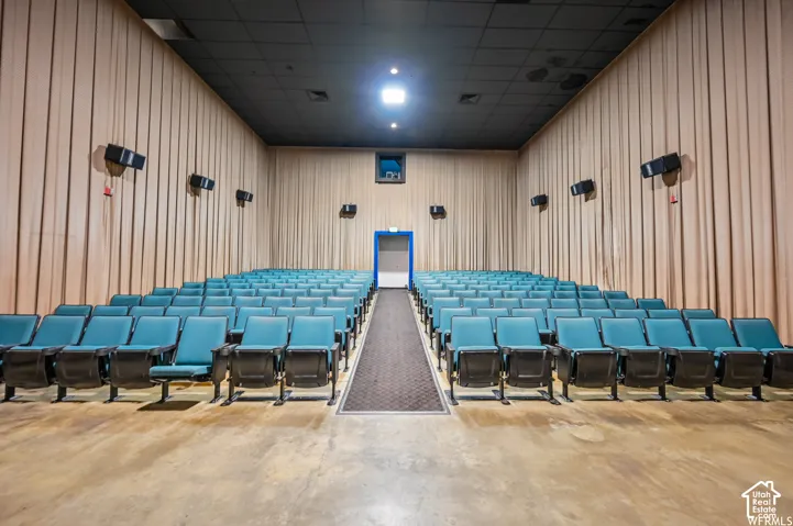 Tiered seating arrangement with fixed theater seats, acoustic wall panels, and a dark ceiling