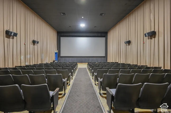 Auditorium featuring tiered seating, a large projection screen, and integrated wall-mounted speakers