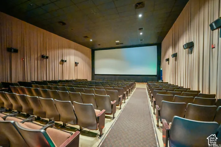 Auditorium featuring tiered seating, a large projection screen, acoustic wall treatments, and ceiling-mounted speakers