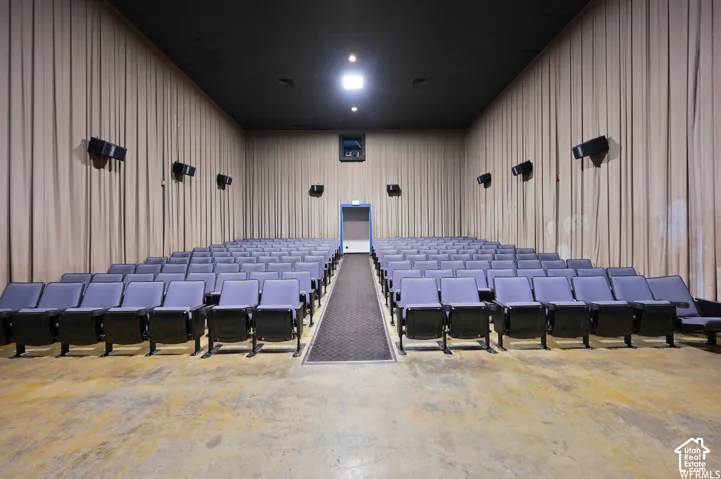 Theater space featuring tiered seating, acoustical wall treatments, overhead lighting, and wall-mounted speakers