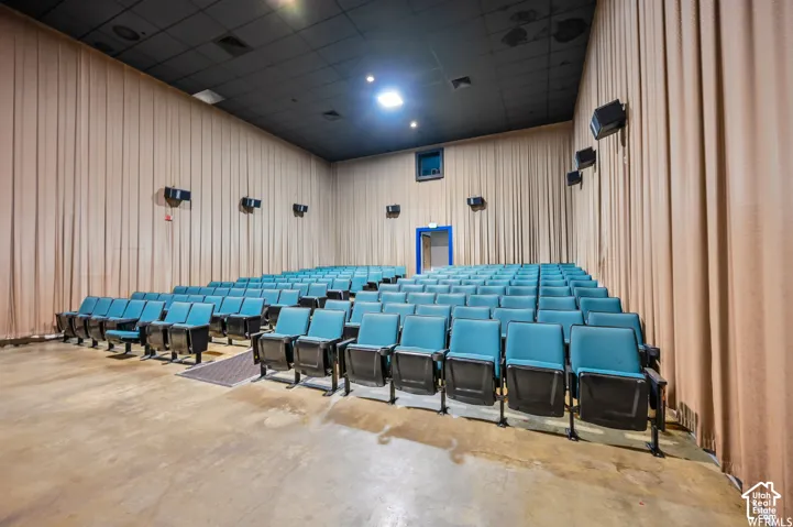 Auditorium featuring tiered seating, acoustical wall drapes, and ceiling-mounted speakers