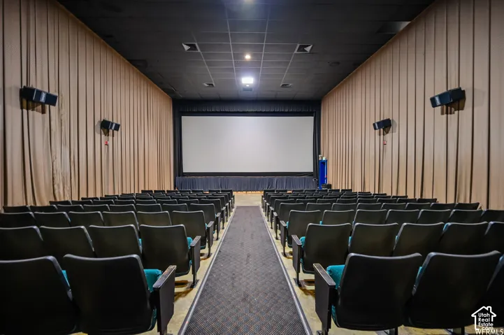 Theater-style seating with padded chairs, large projection screen, and sound system
