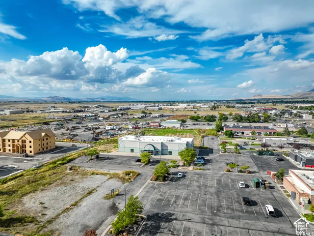 Expansive commercial property featuring a large paved parking area and mature landscaping