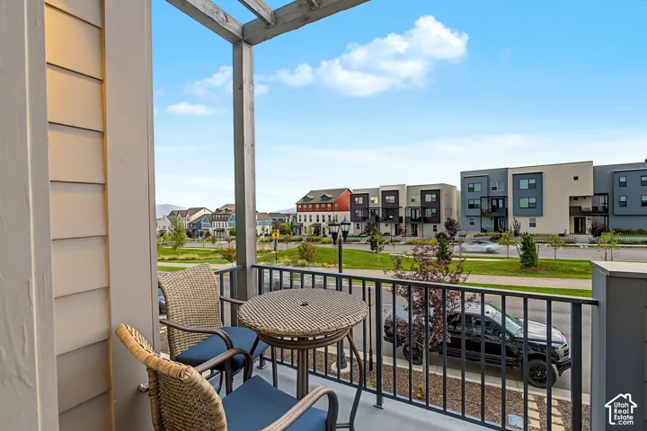 Private balcony with a wooden pergola, metal railing, and siding exterior