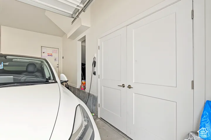 Double panel doors with brushed nickel hardware, concrete flooring, and an electric vehicle charging station