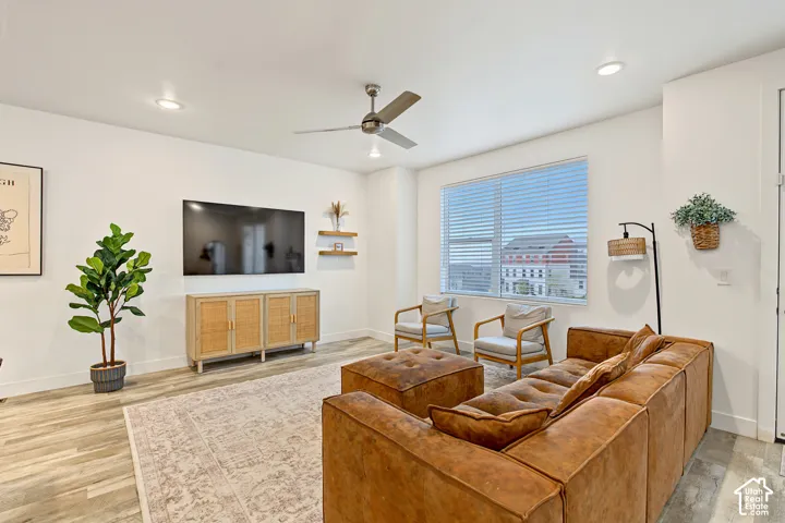 Spacious living area featuring wood-finish flooring, recessed lighting, and a ceiling fan