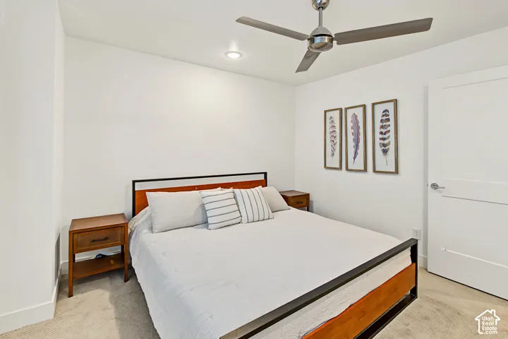 Carpeted room featuring a ceiling fan with integrated lighting, recessed overhead lighting, and a white paneled door with brushed nickel hardware