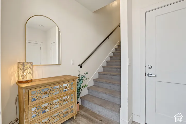 Carpeted staircase with a dark metal handrail