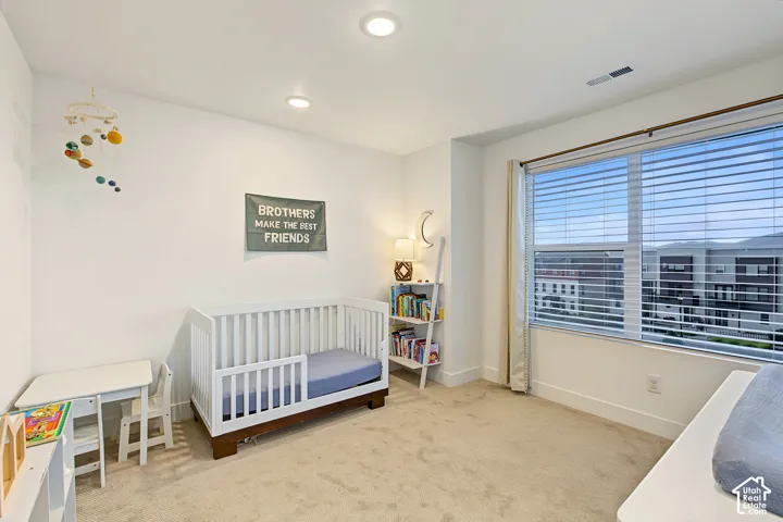 Recessed lighting, large window with blinds, carpeted flooring, white painted walls