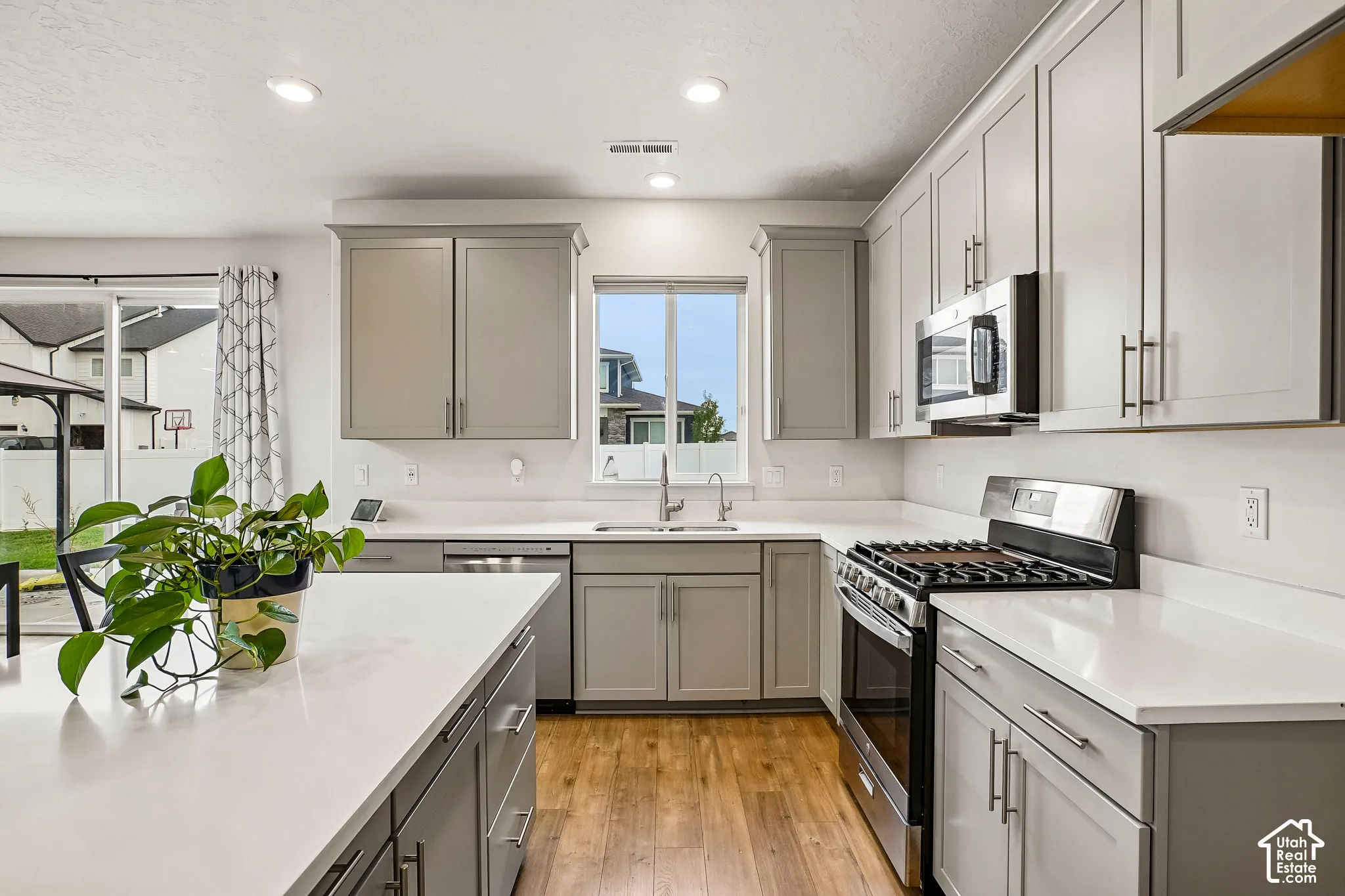 Kitchen featuring wood-finish flooring, recessed lighting, and a kitchen island with a solid surface countertop
