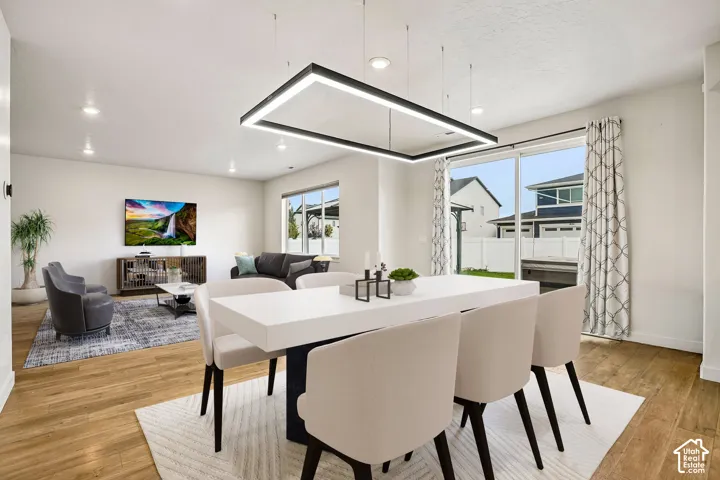 Recessed lighting, wood-finish flooring, and a contemporary linear pendant light fixture