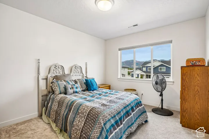 Carpeted room with white walls, a large window, and recessed lighting