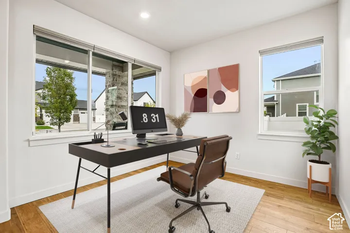 Bright interior space featuring wood-finish flooring and multiple large windows