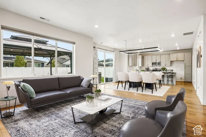 Open-concept living area featuring wood-finish flooring, recessed lighting, and a kitchen with stainless steel appliances