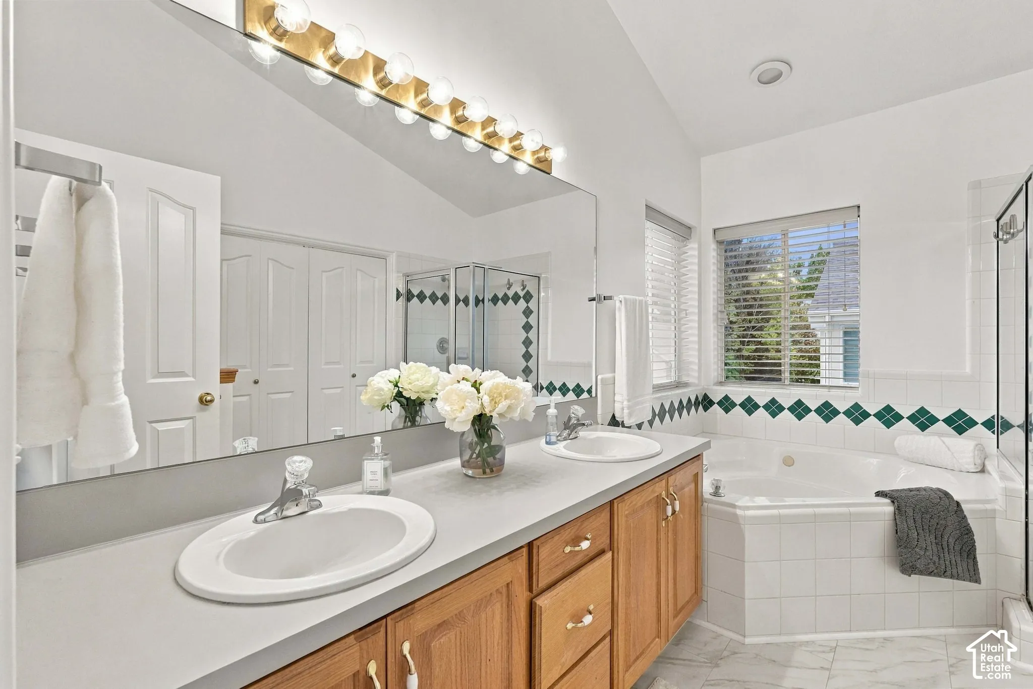 Double vanity and corner jetted tub in primary bedroom