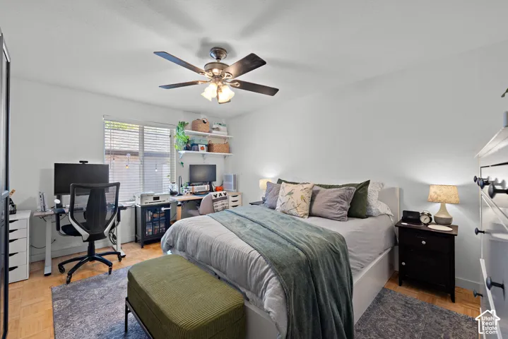 Recessed window with blinds, wood-finish flooring, ceiling fan with integrated lighting, and built-in shelving