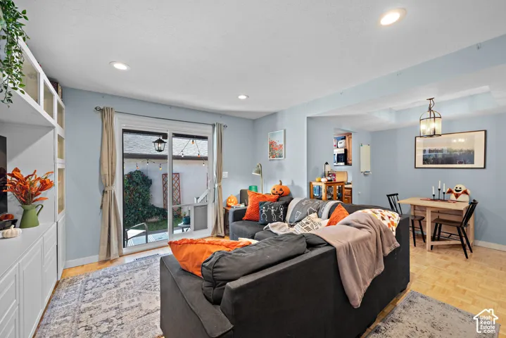 Recessed lighting illuminating a spacious living area with wood-finish flooring