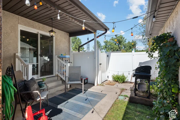 Private patio with concrete flooring, white privacy fencing, and sliding glass door access
