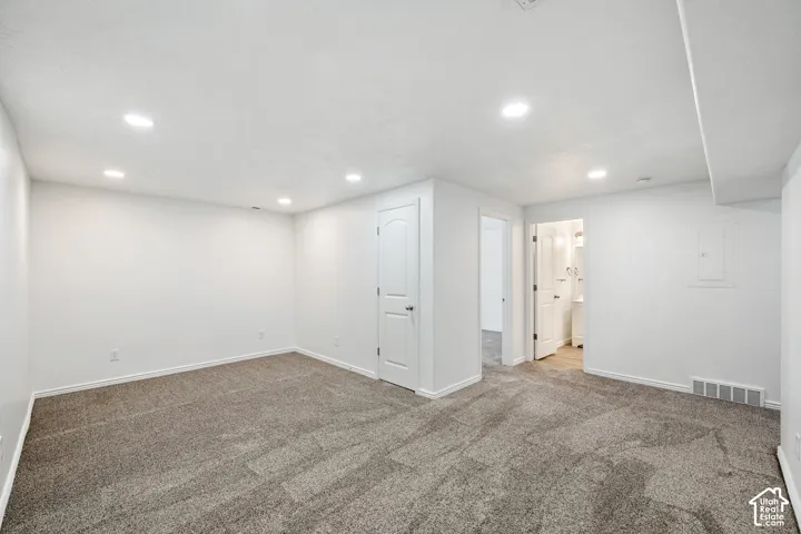 Recessed lighting throughout, neutral-toned carpet, and white interior doors