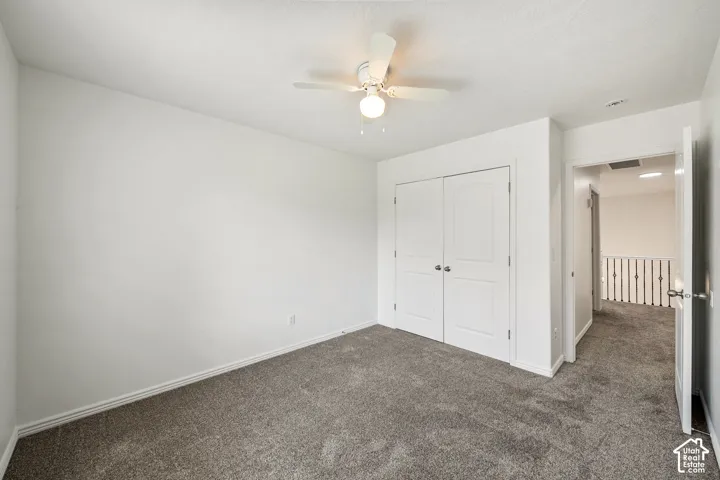 Neutral wall paint, ceiling fan with integrated lighting, soft gray carpeting, and double bifold closet doors