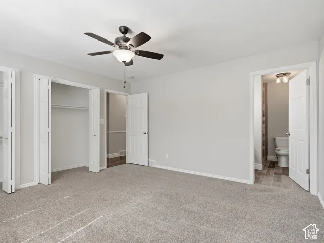 Carpeted flooring, ceiling fan with integrated lighting, bi-fold closet doors, white wall paint, and white trim