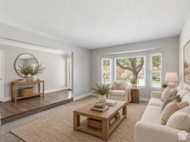 Bay window with natural light, wood-finish flooring, and crown molding