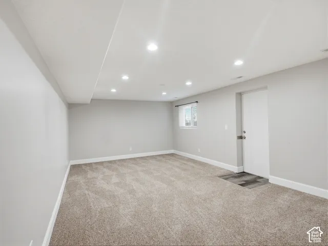 Recessed lighting, light gray wall finishes, carpeted flooring, a single window with blinds, and white trim throughout