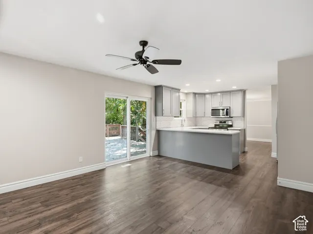 Spacious area featuring wood-finish flooring, a contemporary ceiling fan, and sliding glass doors