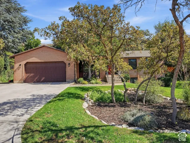 Brick exterior with an attached garage, featuring a dark wood-finish garage door