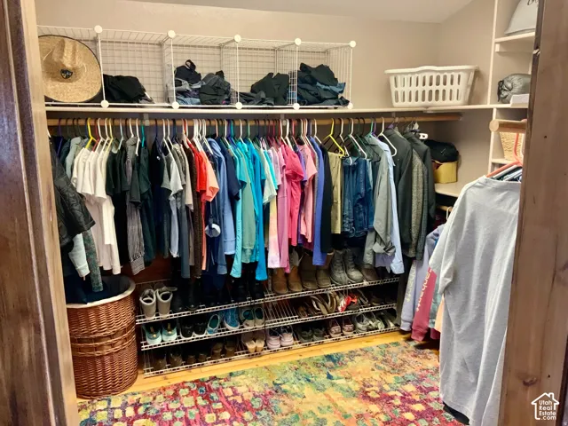Built-in closet organization system with multiple hanging rods, wire shelving, and integrated shoe racks
