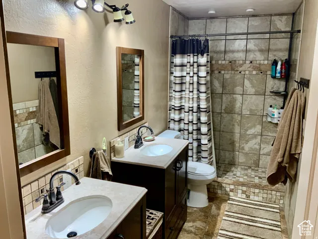 Dual vanity with wood-finish cabinetry, countertop sinks, and bronze-finish faucets