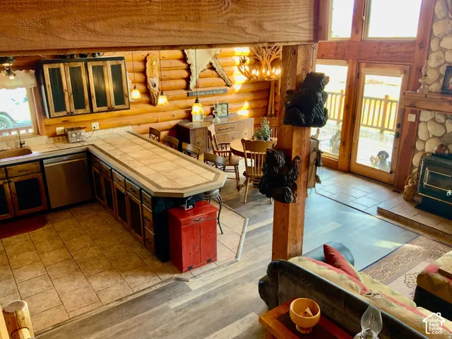Open-concept kitchen with wood-finish cabinetry, tile countertops, and stainless steel appliances