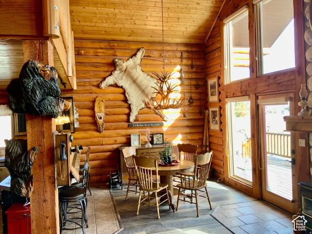 Wood-paneled walls and ceiling, exposed wooden beams, and a wood-finish floor