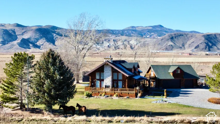 Log-style residence with a stone-clad chimney and a multi-level deck