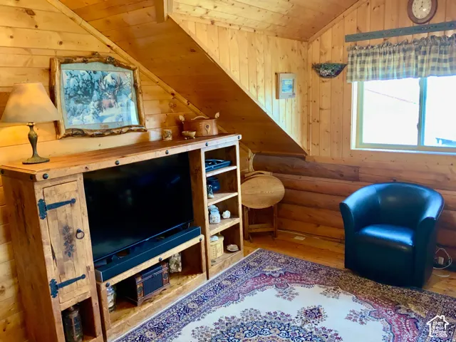 Wood-paneled walls and ceiling, log construction, and wood-finish flooring