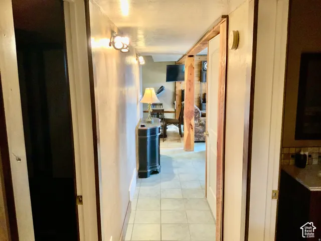 Tiled flooring in a hallway with wall-mounted light fixtures