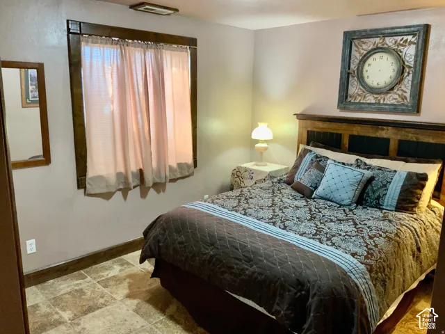 Window with wood-finish trim, overhead flush-mount light fixture, and tile flooring
