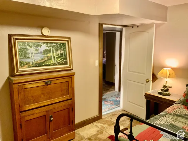 Tile flooring with varied tones, solid wood door with panel detailing, and a built-in wooden cabinet