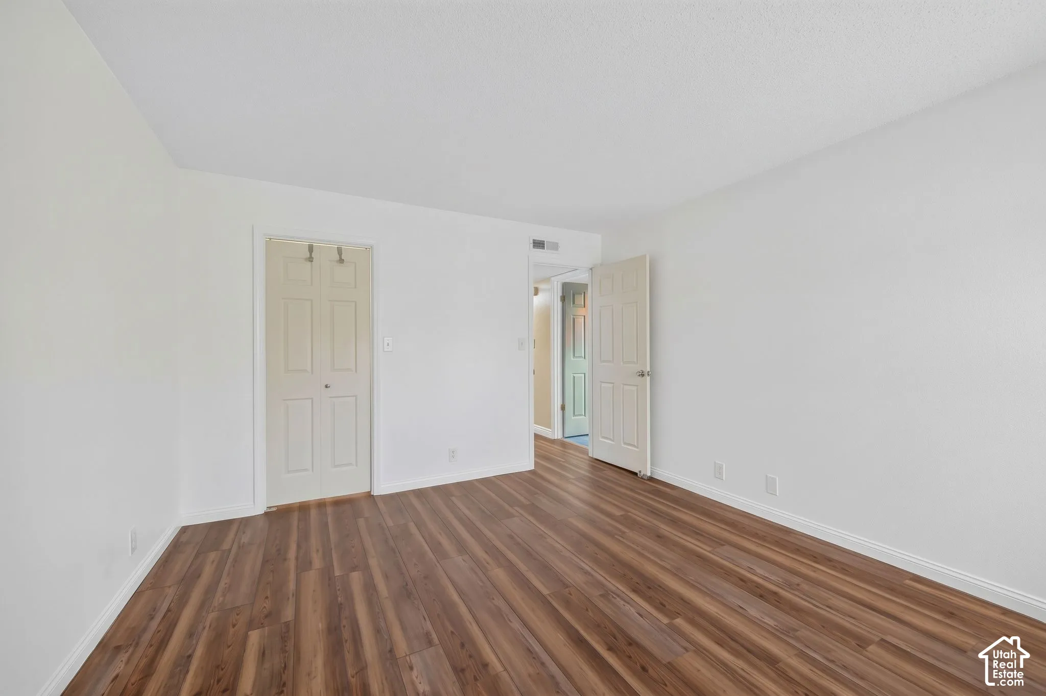 Wood-finish flooring throughout, white walls, and a white ceiling