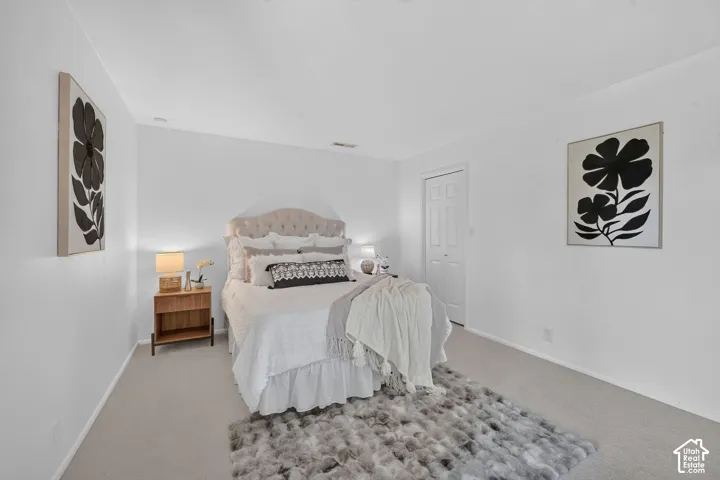 Bright, open primary bedroom with new carpet.
