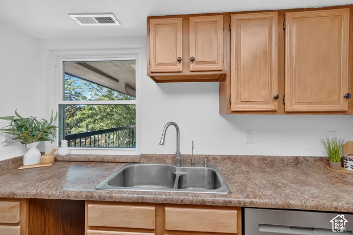 Light wood cabinets and a double sink under the window.