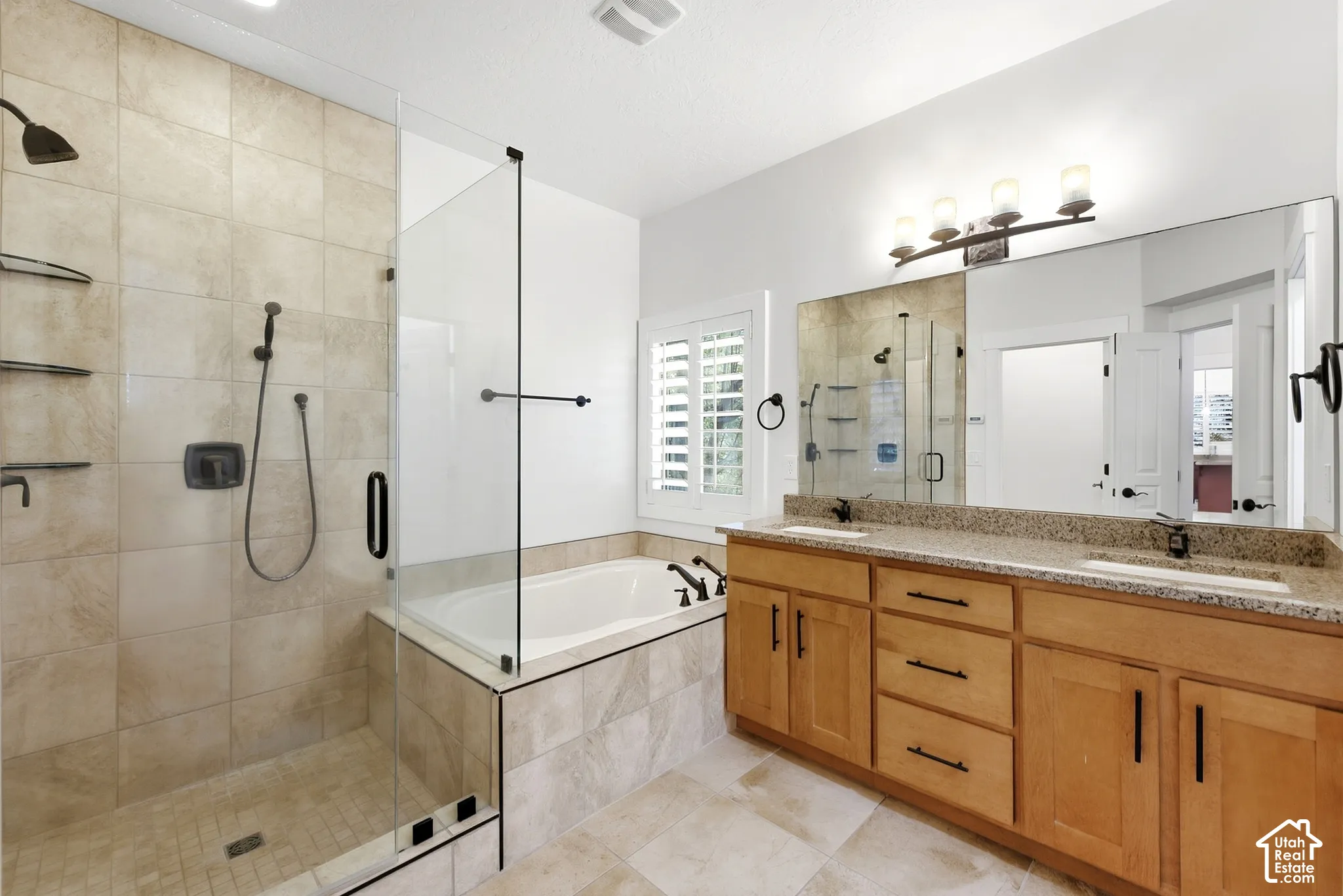 Walk-in shower with glass enclosure, separate soaking tub, and dual vanity with integrated sinks