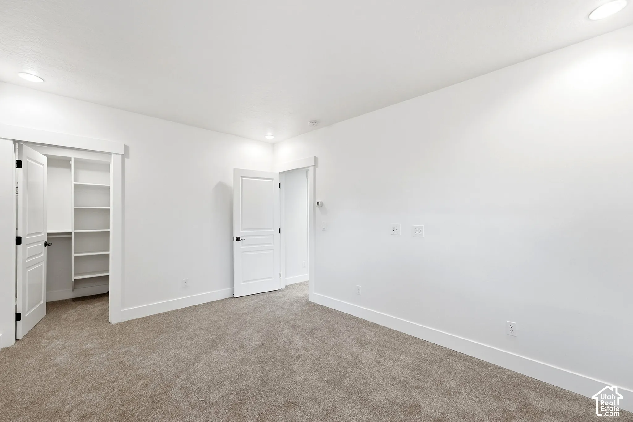 Plush carpet flooring, integrated recessed lighting, and a built-in closet with shelving
