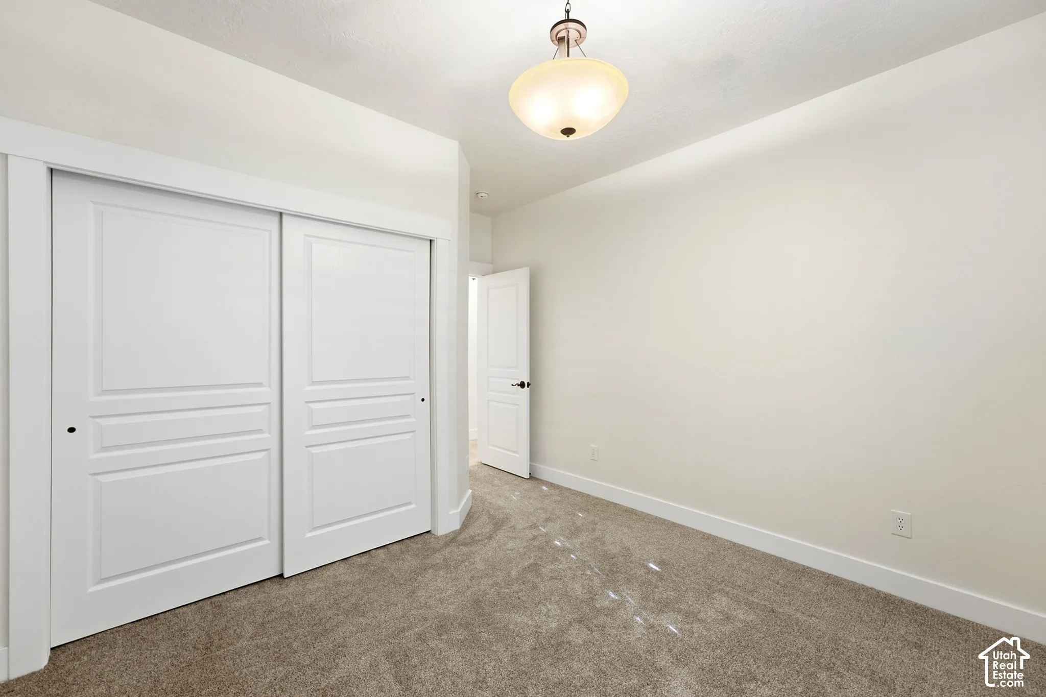 Neutral wall color with recessed lighting, light carpeting, and white trim