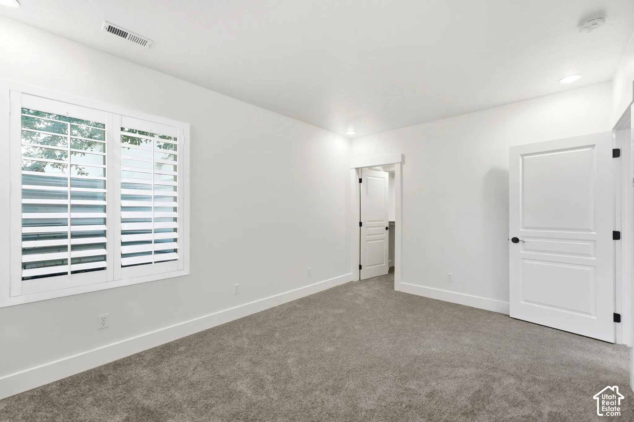 Light gray carpet flooring, white walls, and white trim