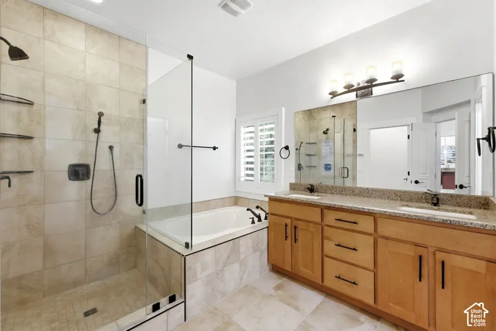 Walk-in shower with glass enclosure, separate soaking tub, and dual vanity with integrated sinks